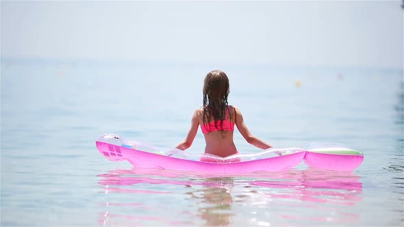 Adorable Girl with Inflatable Mattress in Outdoor Swimming Pool