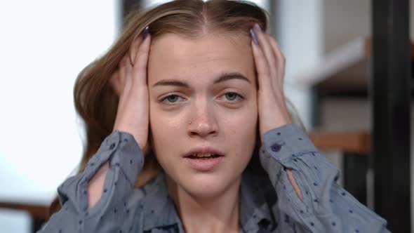 Headshot Stressed Teenage Girl with Panic Attack Breathing Heavily Looking at Camera Holding Head in
