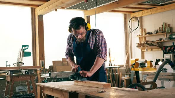 Craftsman Is Cutting Wood with a Sawing Mechanism in Slow Motion