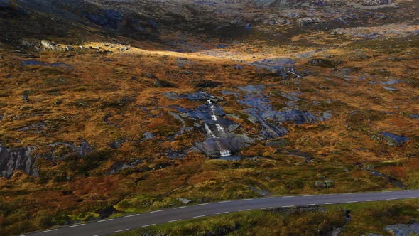 Drone flys towards a waterfall in the norwegian mountains in the Lofoten.