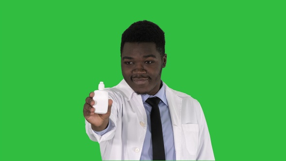 Afro american doctor presenting nasal spray on a Green