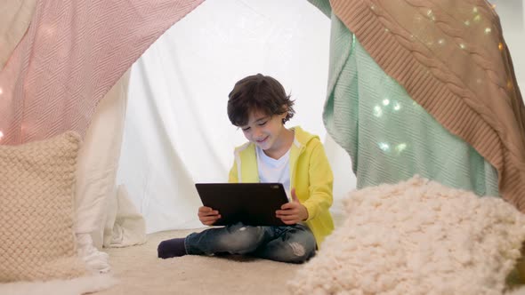 Little Boy with Tablet Pc in Kids Tent at Home