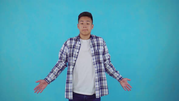 Confused Young Asian Man on Blue Background