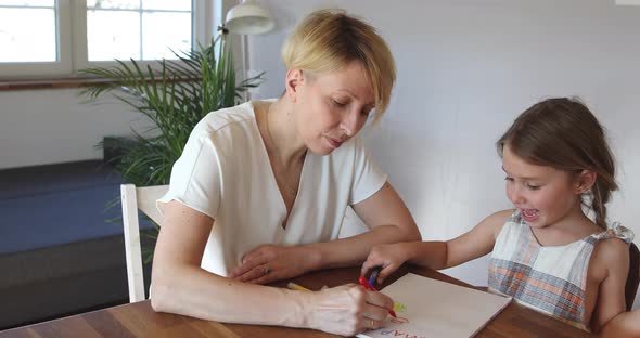 Mother and daughter painting at home