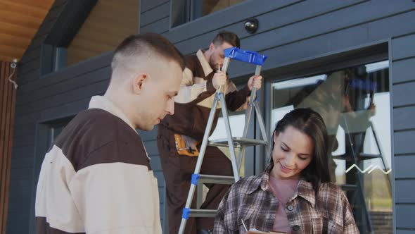 Woman Shaking Hands with Workers Installing Home Security