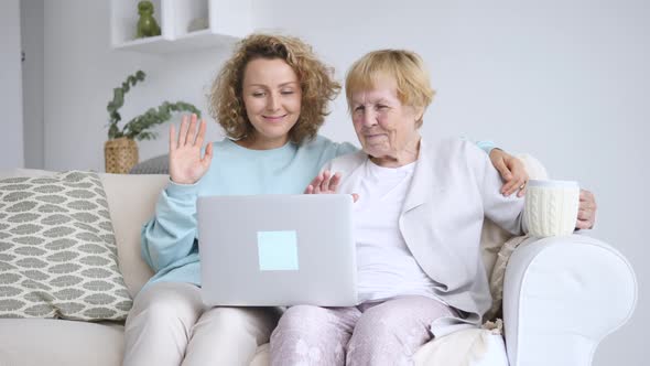 Family, Technology And People Concept - Happy Smiling Granddaughter And Grandmother Having Video