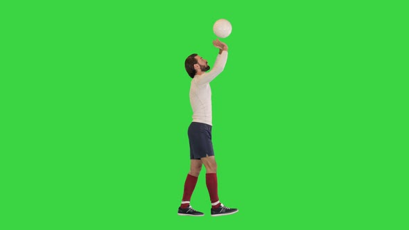 Football Sportsman Walking and Bouncing a Ball in Hands Like a Volleyball Ball on a Green Screen