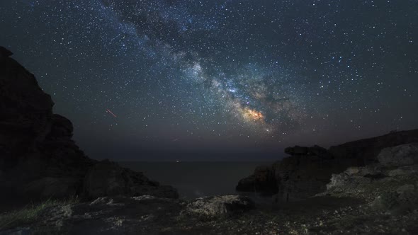 Starry Night Sky Time Lapse with Milky Way over Sea Seen from a Cave