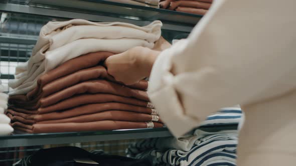 Close up of Asian woman Hand Choosing clothes in a clothing store.