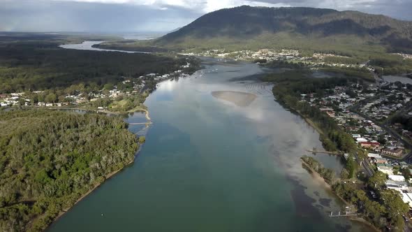 Wide establishing aerial shot featuring prime urban property right next to big beautiful blue river.