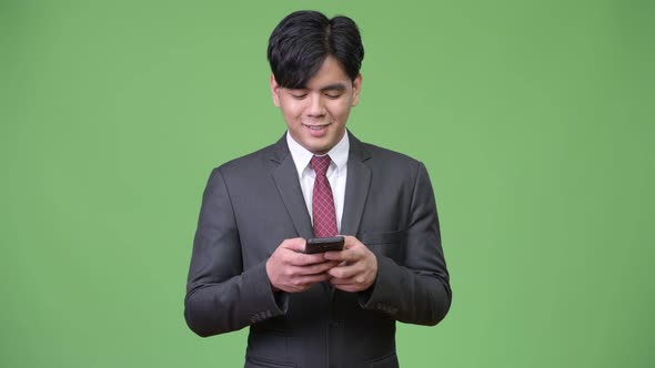 Young Handsome Asian Businessman Using Mobile Phone