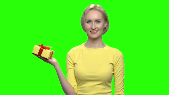 Mature Woman Holding Yellow Gift Box Using One Hand