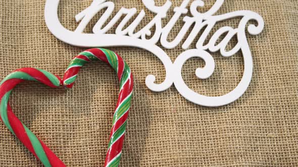 Candy cane with christmas decoration arranged on textile