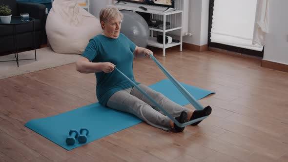 Aged Person Using Elastic Resistance Band to Exercise