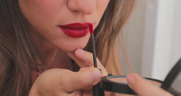 Close Up Slowmotion Footage of How a Girl with a Burgundy Pencil for Makeup Outlines the Contour of