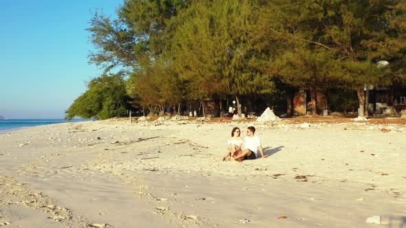 Young couple happy together on tropical coast beach break by blue ocean with white sand background o