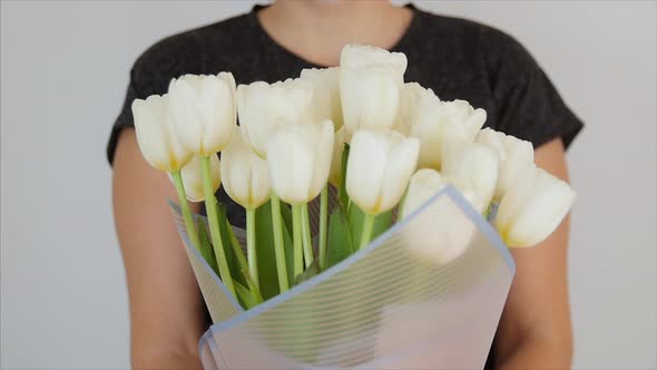 Spring Concept. Woman i Holding White Bouquet of Flowers in a White Background. 