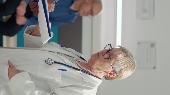 Vertical Video Diverse Medical Team Analyzing Checkup Documents in Office