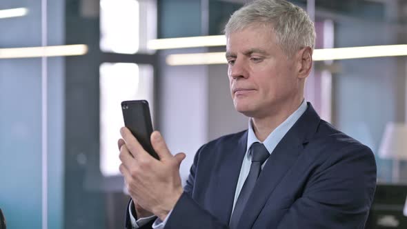 Portrait of Successful Middle Aged Businessman Using Cellphone