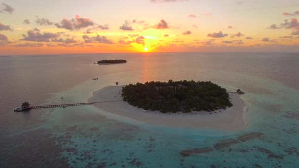 Aerial drone view of scenic tropical islands at sunset in the Maldives.