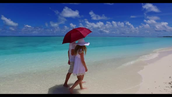 Man and woman tanning on tropical coast beach journey by blue green sea and white sandy background o