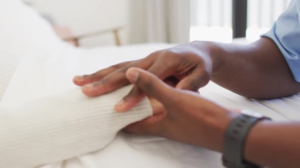 Video of hands of african american male doctor holding caucasian senior woman