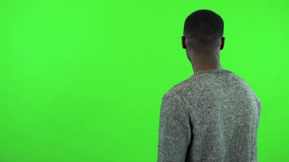 A Young Black Man with His Back To the Camera Waits for Someone - Green Screen Studio