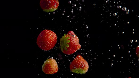 Strawberries Falling into Water Super Slowmotion, Black Background, lots of Air Bubbles, 4k240fps