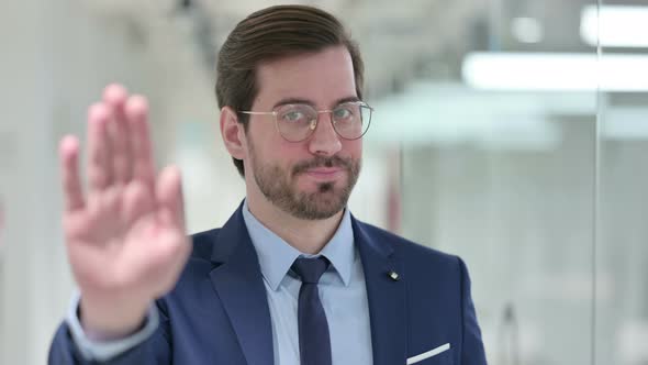 Portrait of Young Businessman Showing Stop Sign By Hand 