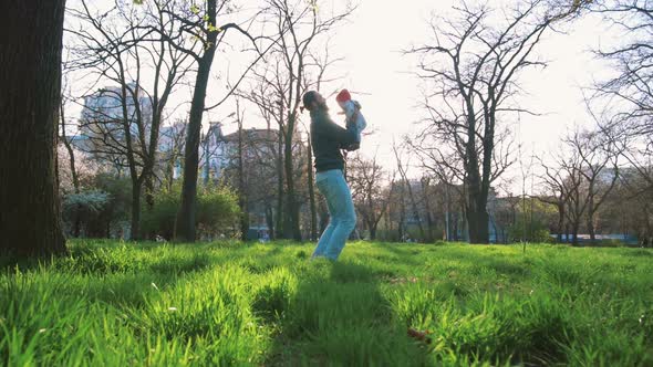 Young Father Throwing Up His Little Daughter in the Air and Having Fun in Park Slow Motion