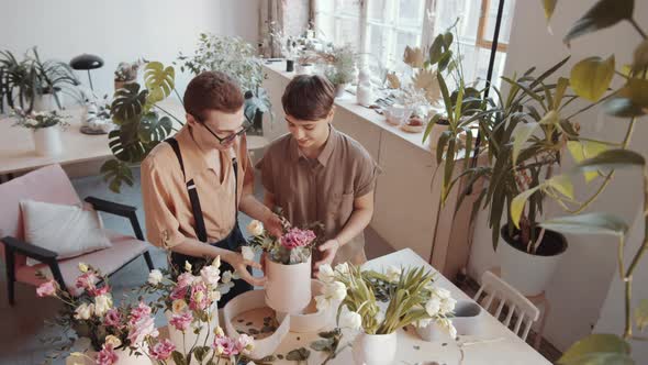 Cheerful Male and Female Florists Making Bouquet Together in Flower Shop