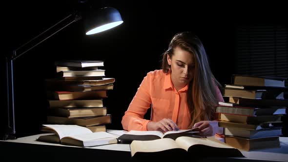 Girl Reads and Writes Information in a Notebook. Black Background
