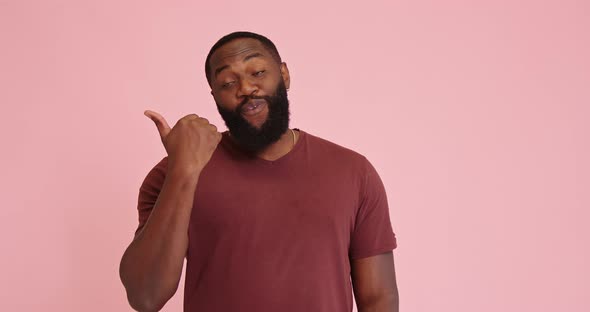 Young African American Man Point Out with Thumb Isolated on Pink Background