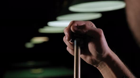 Handsome Bearded Man Rubbing Cue with Chalk at Bar