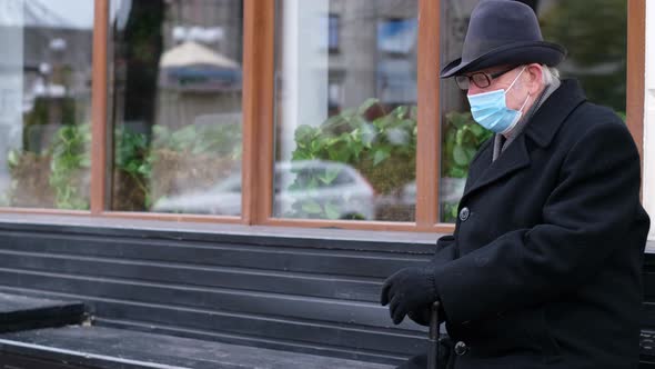The Pensioner is Resting on a Bench in the City During Quarantine