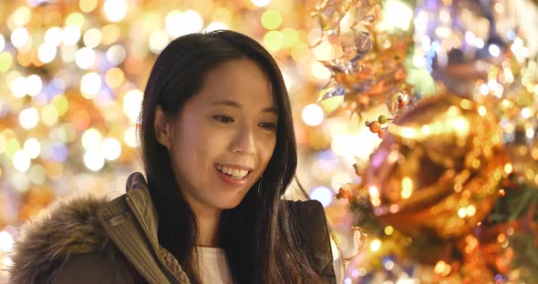 Asian Woman looking at the christmas tree decoration 