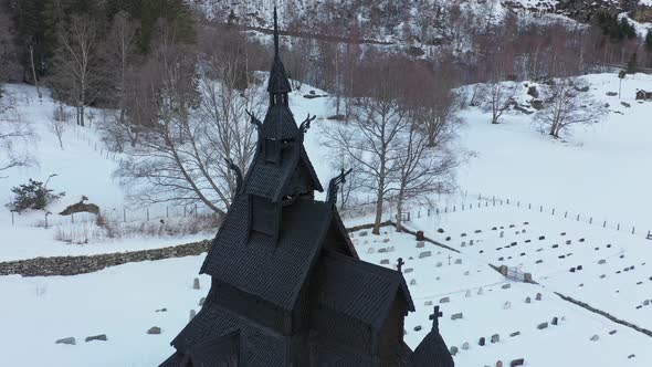 Borgund stave church winter aerial - Slowly descending from top of tower to reveal whole church and