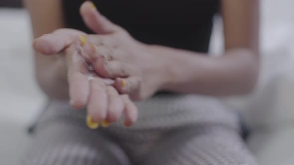 Close-up of Young African American Hands with Bright Manicure Applying Hand Cream. Fashion Girl