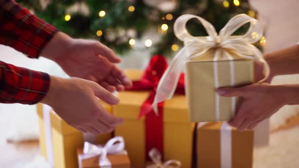 Hands Giving and Receiving Christmas Gift Box