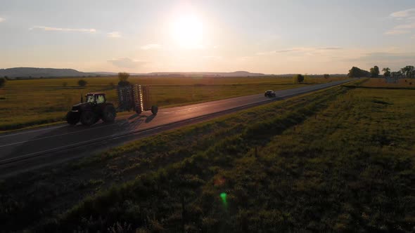 Aerial shot: agricultural tractor driving by road.