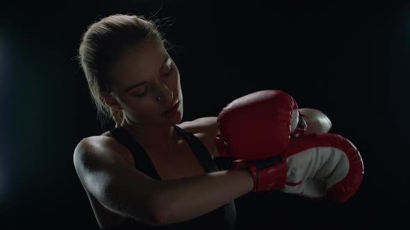 Woman Fighter Preparing for Sport Workout in Dark Gym. Portrait of Woman Boxer