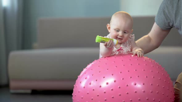 Cute Healthy Baby Enjoying Jumping on Big Ball, Fitness Exercises for Infants