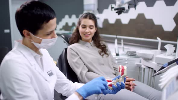 Female Dentist Showing Patient How to Brush Teeth