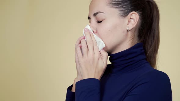 Portrait of Young Woman Blows Her Nose Into Napkin, Sneezes and Coughs, Isolated