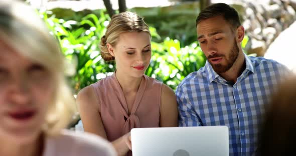 Couple using laptop at restaurant