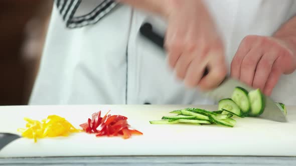 Hands of Chef Cutting Cucumber.