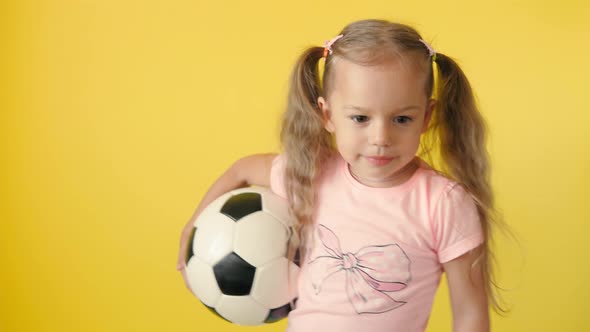 Authentic Cute Smiling Preschool Little Girl with Classic Black and White Soccer Ball Look at Camera