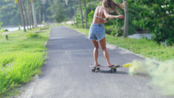4K Young sian woman skating on skateboard in the park at tropical island