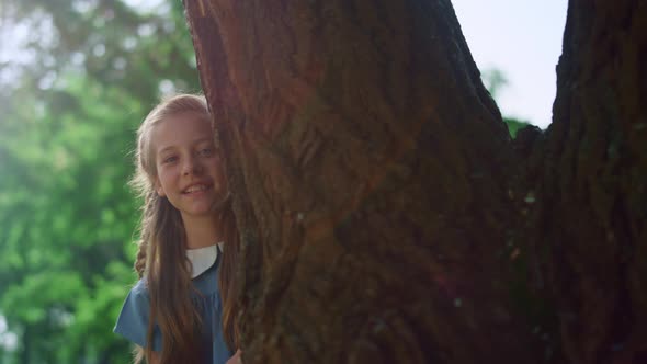 Cute Blond Girl Looking Out Huge Tree Trunk