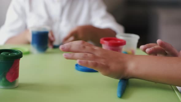 Cropped View of Children Making Figurines From Plasticine at Home